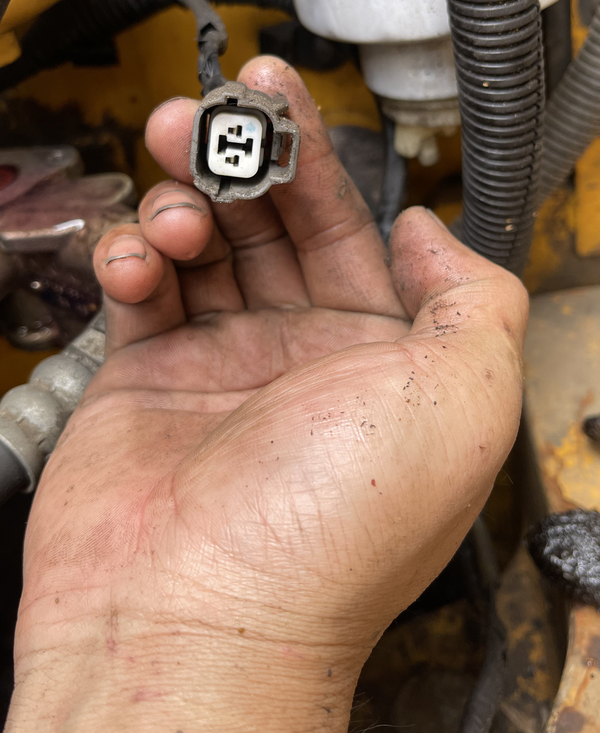 A hand-held grey connector housing with a white internal face and locating features.